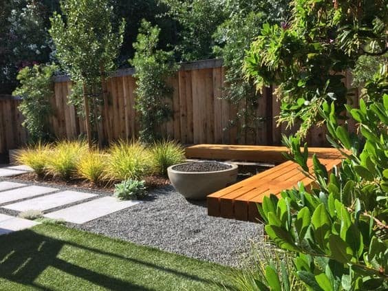A modern garden zen with wooden benches and buried concrete stepping stones