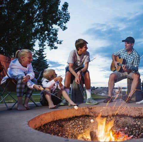 A family enjoying the fire pit while roasting some marshmallows