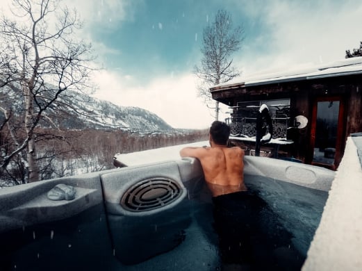 A romantic hot tub cabin retreat with a view of nature in winter