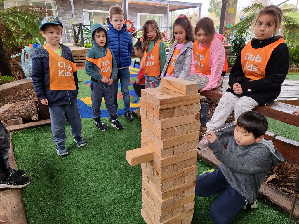 A kid pushing a giant Jenga block