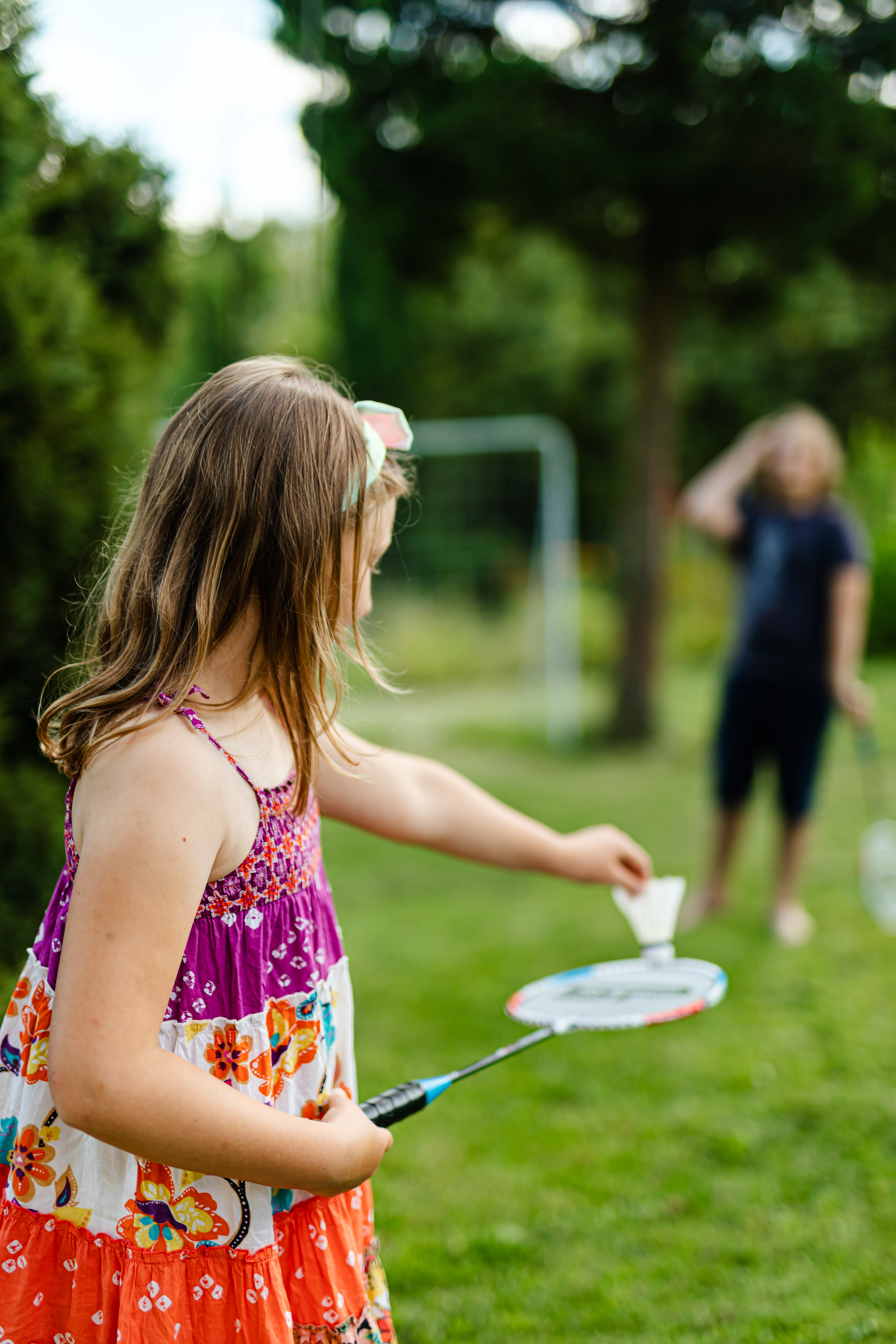 A girl playing badminton on the lawn