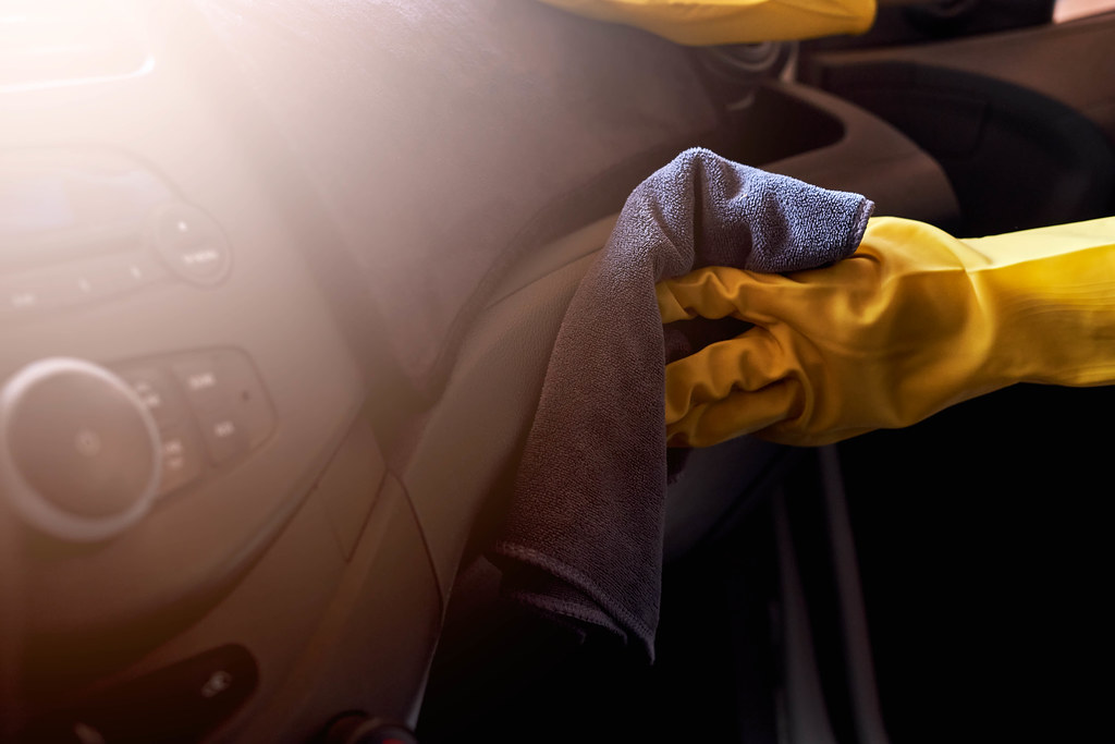 A person wiping the car's dashboard
